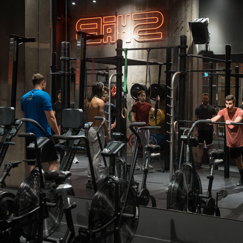 The SHĀB open gym floor with rigs, bikes, and rowers